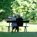 公園のベンチに寄り添って座る老夫婦