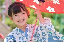 和傘をさした着物姿の笑顔の女の子