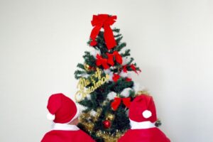 クリスマスツリーとサンタの衣装を着た子供