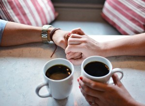 カフェで手を繋ぐカップル