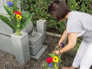 お墓参りでお花を供える女性