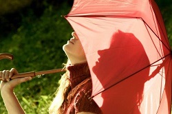 日傘をさして空を仰ぐ女性