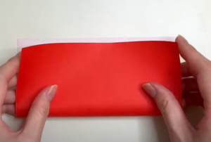 赤い折り紙を半分に折る