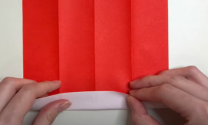 折り紙を表側に開き、さきほどつけた折り目が垂直になるように置き、下から2センチほどの幅で折り返す