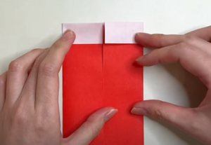 折り紙の2センチ折った側を上にして裏返しにしたら、両側を中央に向けて折る