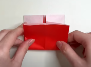 折り紙の2センチ折った側を上にして裏返しにしたら、両側を中央に向けて折る。その状態で上に向けて半分に折る