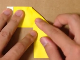 半分に折った黄色の折り紙を斜めに折る
