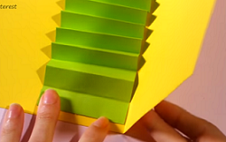 黄色の台紙に蛇腹に折った緑の画用紙を貼る