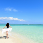 沖縄のきれいな海辺を歩く女性