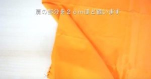 オレンジの布を縫う