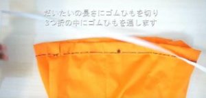 縫ったオレンジの布にゴムを通す