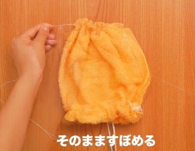 縫い終わったオレンジのフェイスタオルをすぼめる