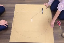 マジックとタコ糸でダンボールに大きな円を描く