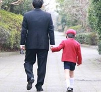 公園を歩く父親と男の子