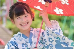 和傘を指した浴衣姿の笑顔の女の子