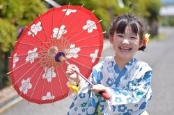 和傘を持った浴衣姿の笑顔の女の子