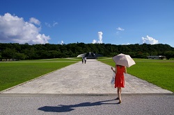 青空　日傘を指して歩く女性